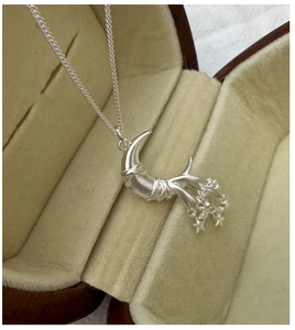 Detailed view of S925 sterling silver moon and star pendant in a vintage jewelry box