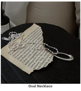 Macro detail of S925 sterling silver oval pendant and bead chain on vintage background