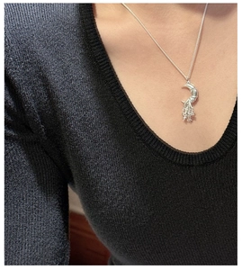 Detail of S925 sterling silver moon and star pendant necklace on a neck model
