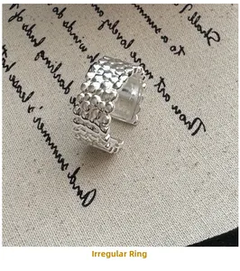 Macro shot of silver ring featuring irregular lava texture on an open band design