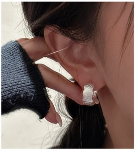 Close-up of S925 sterling silver hoop earrings with vintage floral relief and matte finish
