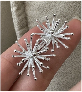 Macro shot of 925 silver vintage firework stud earrings with 3D radial design details