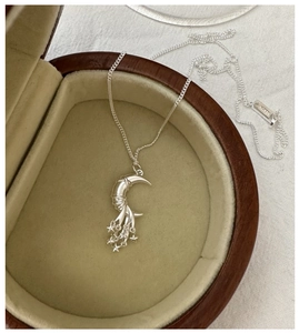 Detail of S925 sterling silver moon and stars pendant necklace in a brown jewelry box