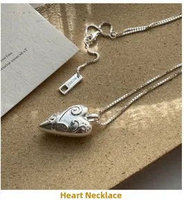 Close-up of S925 sterling silver heart necklace with vintage totem texture on box chain