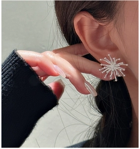 Macro shot of S925 silver vintage firework stud earrings on model's ear