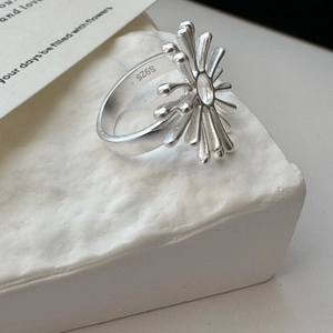 Minimalist S925 sterling silver sunburst ring with matte finish on a stone pedestal