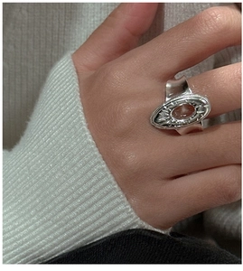Detail of vintage silver ring with oval amber stone and radial texture on finger