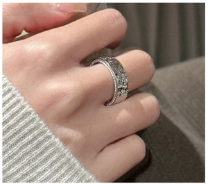 Detailed close-up of S925 sterling silver hammered wide ring with pavé diamond edges
