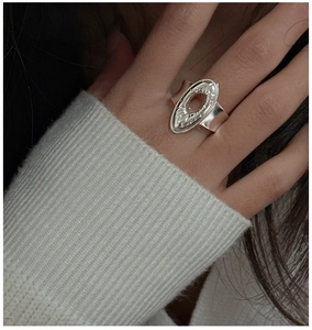 Detail of S925 sterling silver ring featuring oval hollow design and radial carved texture