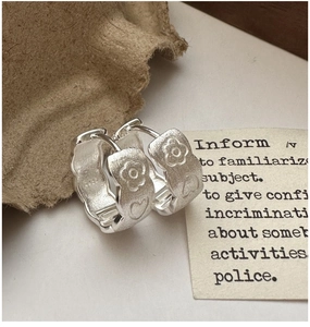 Detailed macro view of S925 sterling silver floral hoop earrings with heart pattern