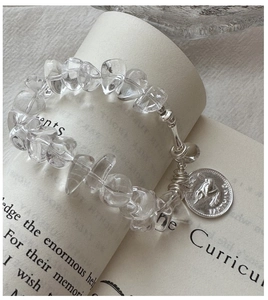 Close-up of S925 silver bracelet with white crystal beads and retro bird coin charm