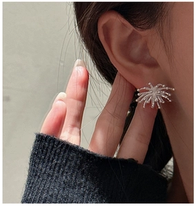 Close-up of vintage S925 sterling silver firework stud earrings worn by a model