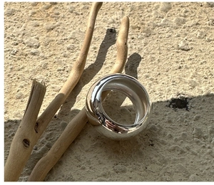 Close-up of a minimalist polished S925 silver chunky ring on a natural stone surface