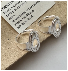Detail of vintage silver adjustable rings with sunburst engraving and hollow center design