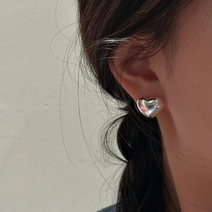 Minimalist S925 sterling silver hollow heart stud earrings worn on a model's ear
