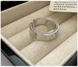 Detailed close-up of textured S925 silver ring with micro-pave crystals in a box