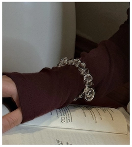 Detail of beaded S925 silver bracelet with white crystal and engraved bird charm