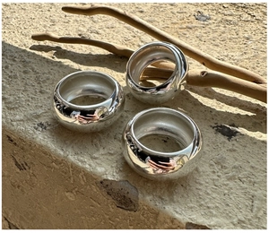 Macro shot of three S925 sterling silver minimalist rings with polished mirror finish