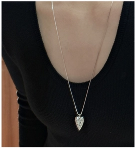Close-up of S925 silver heart necklace with intricate vintage engraving on model
