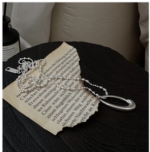 Macro detail of S925 sterling silver oval pendant with AG925 hallmark on a vintage paper