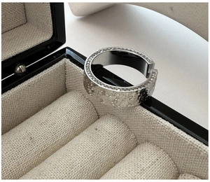 Macro shot of silver textured hammer pattern ring with side row of micro-inlaid zircons