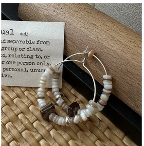 Macro detail of S925 silver retro beaded hoop earrings featuring white and marble beads