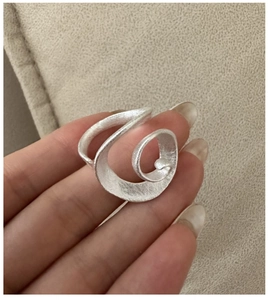 Macro detail of S925 sterling silver ring featuring a vintage swirling streamlined design