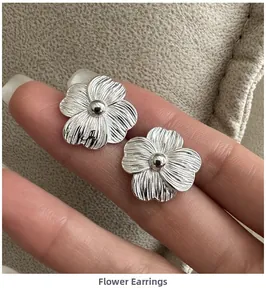 Detailed close-up of S925 silver flower earrings with textured brushed metal petals