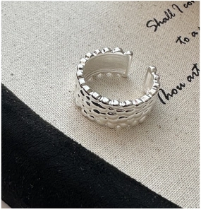 Macro shot of silver adjustable ring featuring molten lava texture and scalloped edges