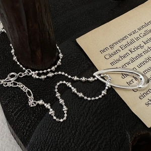Minimalist S925 sterling silver necklace with teardrop pendant on vintage paper background