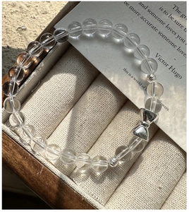 Macro view of crystal beads bracelet with a silver bow charm on a velvet jewelry box