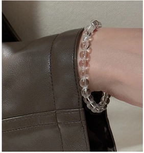 Detailed view of clear white crystal beaded bracelet with S925 silver bow on wrist