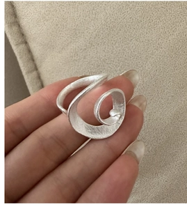 Detailed view of wide spiral S925 sterling silver ring with a matte brushed finish texture