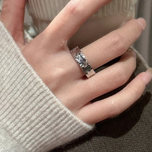 Minimalist S925 sterling silver ring with hammered texture worn on a hand in cozy lighting