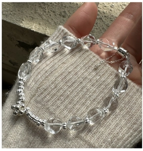 Détail du bracelet en argent S925 avec perles en cristal blanc et breloque fleur