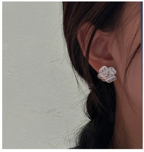 Close-up of S925 sterling silver flower earring with detailed radial texture on petals