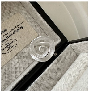 Macro shot of S925 sterling silver spiral ring with a brushed matte texture and modern look