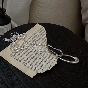 S925 sterling silver ball chain necklace with water drop pendant on black textured fabric