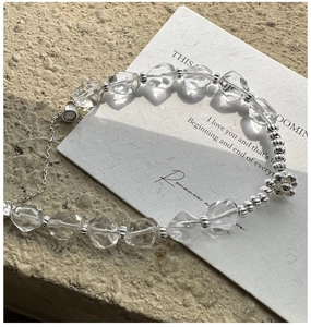 Vue macro d'un bracelet en argent S925 avec perles de cristal et un petit charme floral