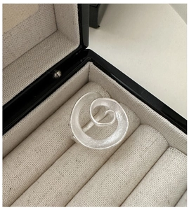 Close-up of S925 sterling silver spiral ring with matte texture in a premium gift box
