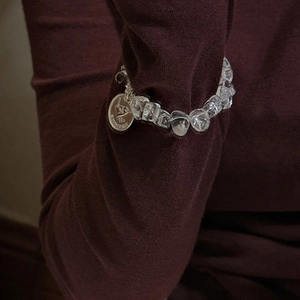 Retro S925 silver bird coin bracelet with clear crystal beads on a person's wrist