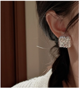 Close-up of S925 sterling silver square earrings with a woven texture on model