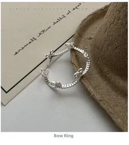 Detailed shot of an adjustable S925 silver bow ring with bead texture on a vintage hat