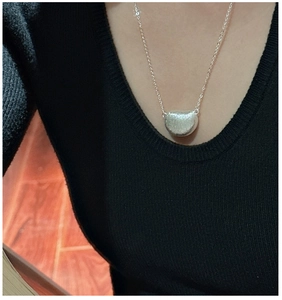 Detailopname van S925 sterling zilveren bonenhanger met matte afwerking aan een ketting