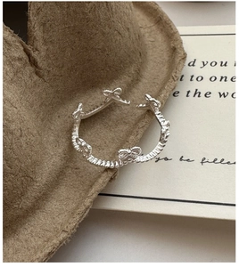 Close-up of S925 sterling silver bow ring with vintage woven texture and metallic finish