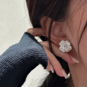 Elegant S925 sterling silver flower stud earrings worn by a model in a close-up side view