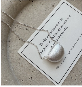Macro detail van zilveren minimalistische boonhanger met een geborstelde metalen textuur