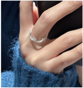 Macro detail of silver bow ring featuring unique wavy texture on the polished band