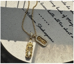 Detail of S925 silver beaded necklace with gold Pixiu and Vajra pendants with rhinestones