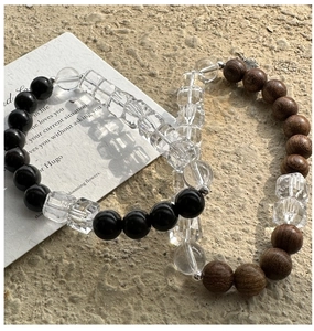 Detailed shot of S925 silver beaded bracelets with black onyx and wood beads on stone texture